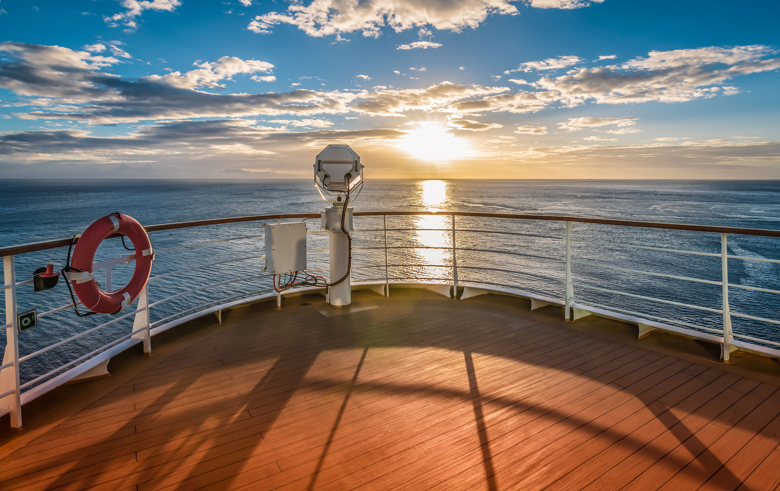 Wooden deck and railing from cruise ship Beautiful sunset and o